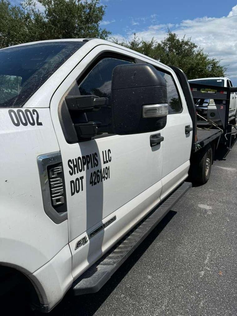 Shoppiis LLC truck, DOT 4261491, hauling a vehicle in Florida