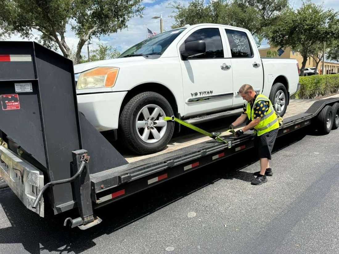 Shoppiis operator securing a customer vehicle on the trailer in the Southeast